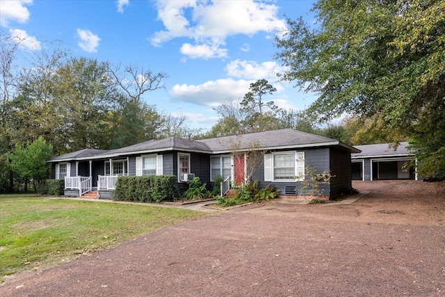 ranch-style home with an outbuilding, covered porch, a front yard, and a garage