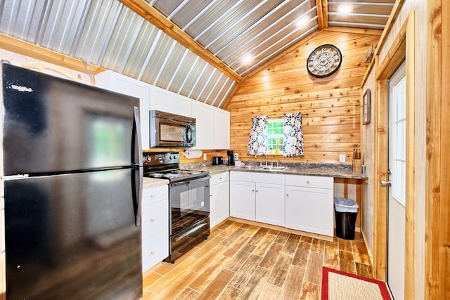 kitchen featuring white cabinets, stainless steel fridge, lofted ceiling, and black electric range