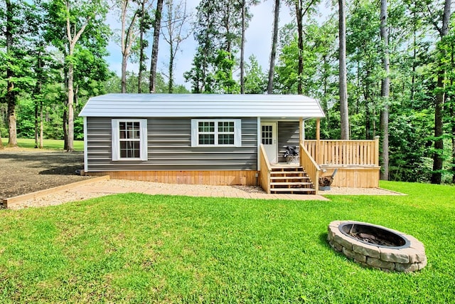 view of outdoor structure featuring a lawn and an outdoor fire pit