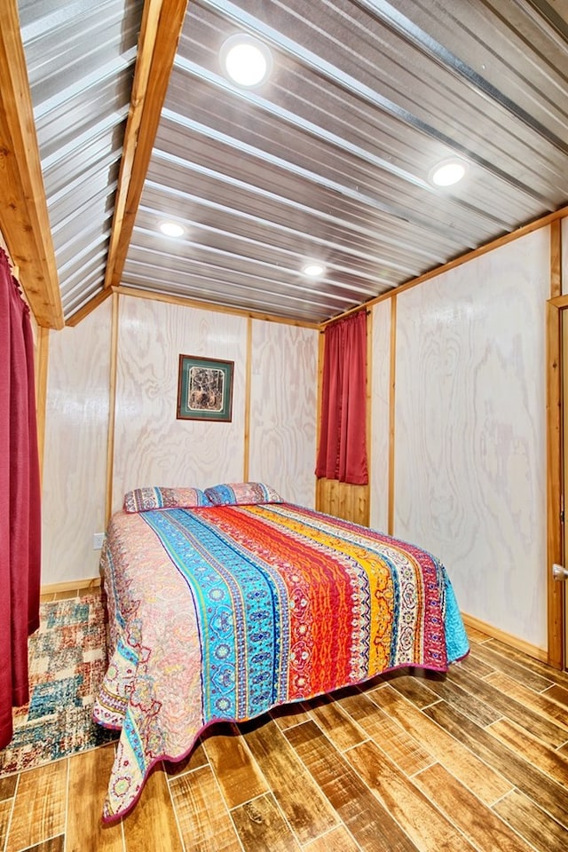 bedroom with lofted ceiling and wood-type flooring