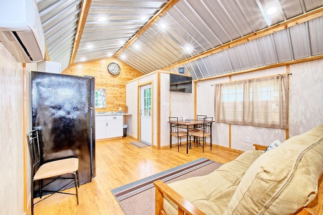 living room with lofted ceiling, light hardwood / wood-style floors, plenty of natural light, and wooden walls