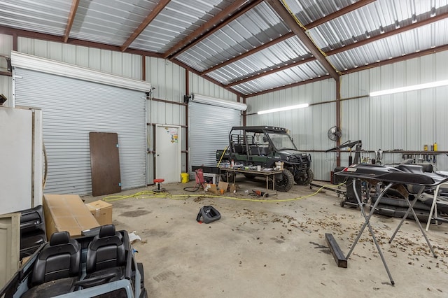 garage featuring metal wall and freestanding refrigerator