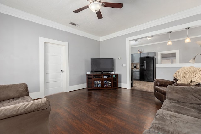 living room featuring ceiling fan, dark wood-type flooring, visible vents, baseboards, and ornamental molding