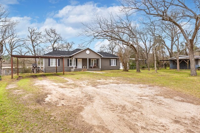 view of front of home with driveway, a front lawn, a porch, and fence