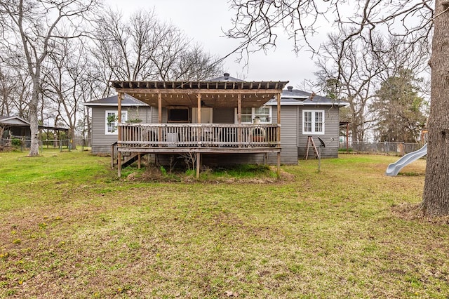 back of house with fence, a deck, and a lawn