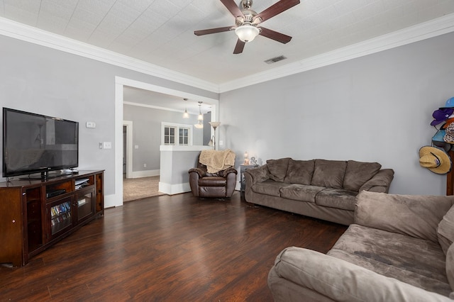 living area with wood finished floors, visible vents, baseboards, a ceiling fan, and ornamental molding