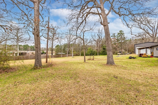 view of yard featuring fence and an outbuilding