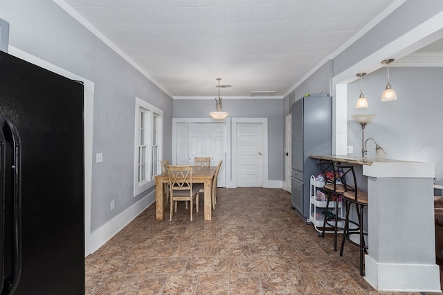 dining room featuring baseboards, stone finish flooring, visible vents, and crown molding