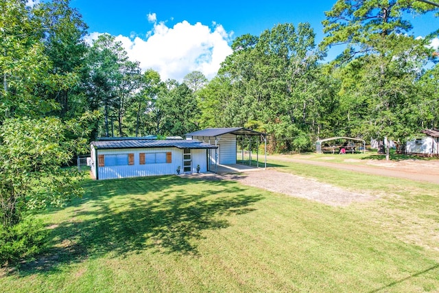 view of front of house featuring metal roof, a front lawn, a carport, and dirt driveway