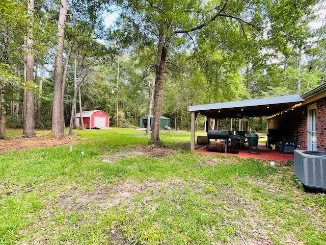 view of yard featuring a patio area, cooling unit, and a shed