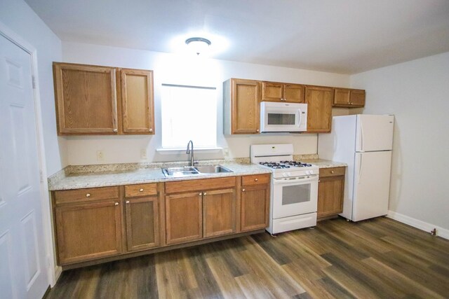 kitchen featuring white appliances, dark hardwood / wood-style flooring, and sink