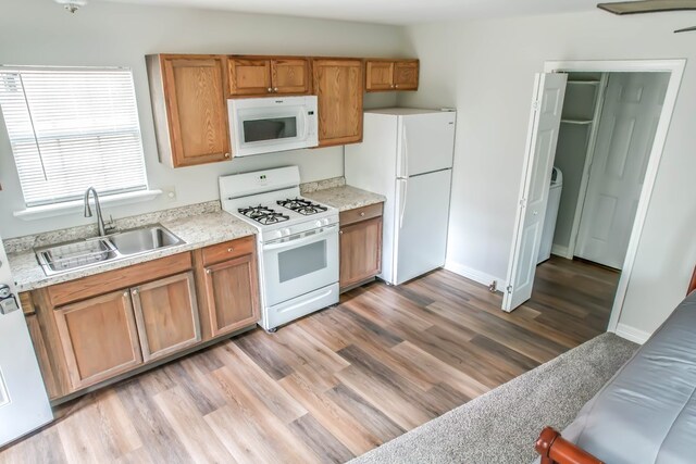 kitchen featuring white appliances, sink, and light hardwood / wood-style flooring