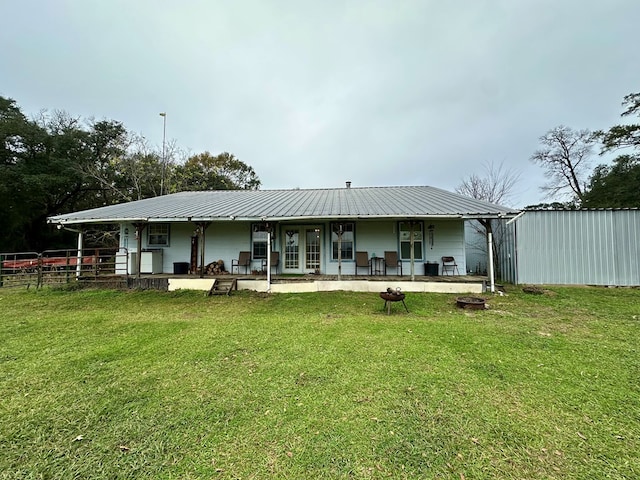 rear view of property featuring a porch and a yard