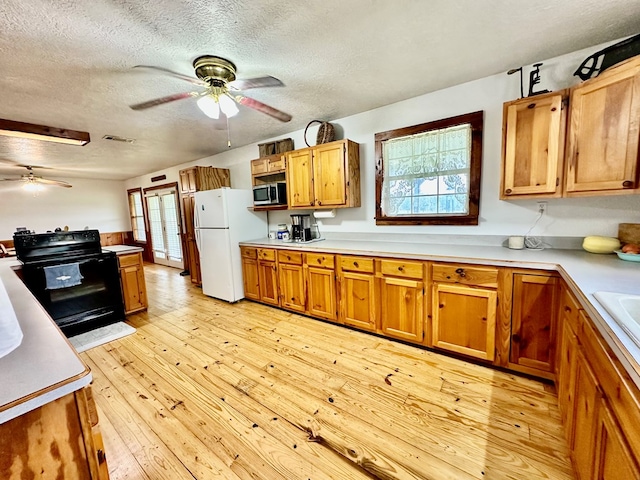 kitchen with a textured ceiling, ceiling fan, white refrigerator, light hardwood / wood-style floors, and black range with electric stovetop