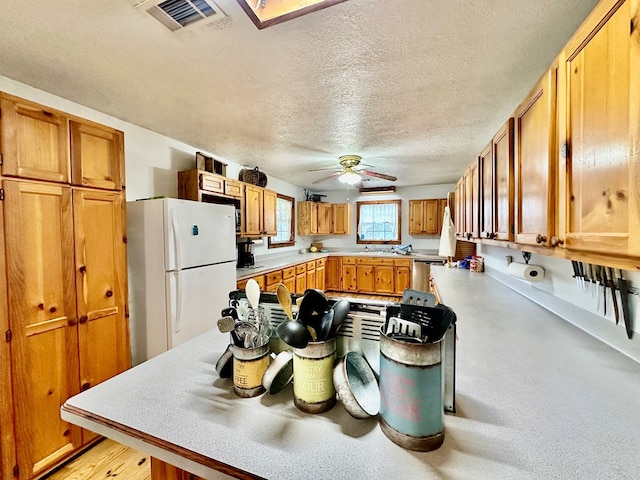 kitchen with stainless steel dishwasher, a textured ceiling, ceiling fan, sink, and white fridge