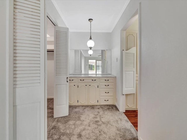 kitchen with light colored carpet, hanging light fixtures, and crown molding