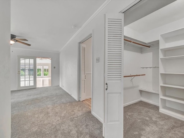 walk in closet with light colored carpet and ceiling fan