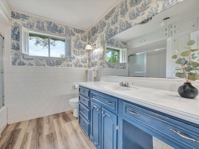 bathroom featuring plenty of natural light, vanity, hardwood / wood-style floors, and tile walls