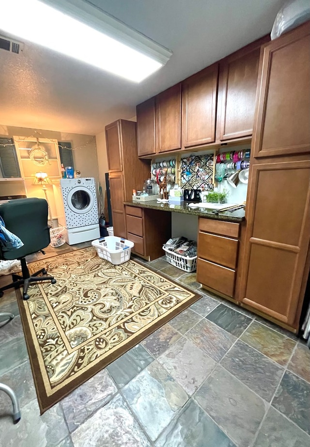 708 Card Dr, Lufkin, TX 75901 - kitchen with brown cabinets, stone finish flooring, visible vents, and washer / dryer