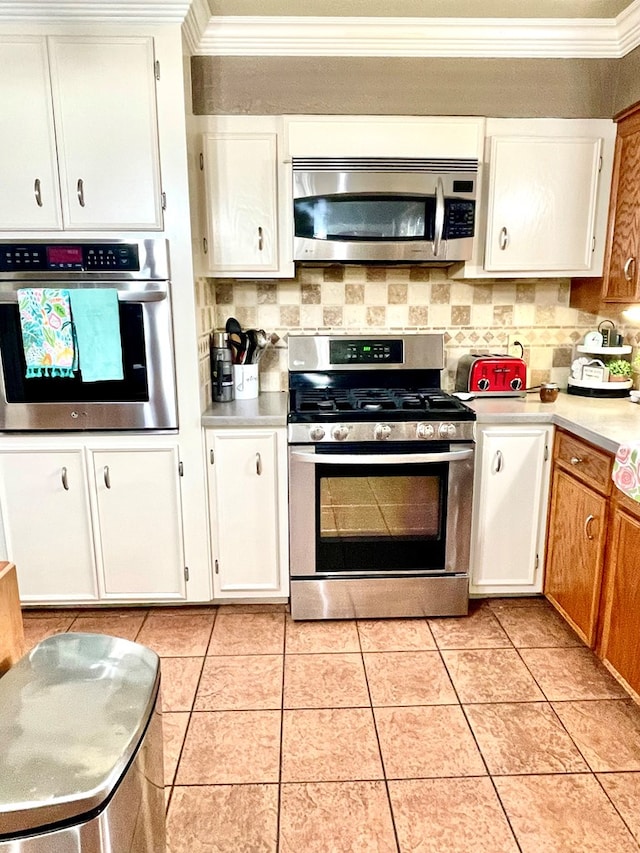 708 Card Dr, Lufkin, TX 75901 - kitchen with light countertops, appliances with stainless steel finishes, ornamental molding, and white cabinets