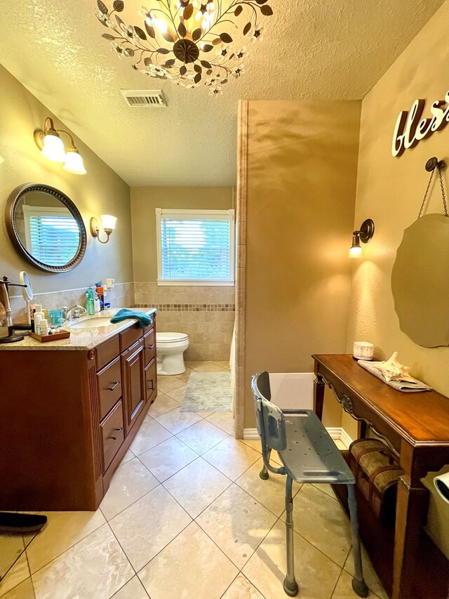 708 Card Dr, Lufkin, TX 75901 - bathroom featuring a textured ceiling, visible vents, tile walls, tile patterned flooring, and toilet