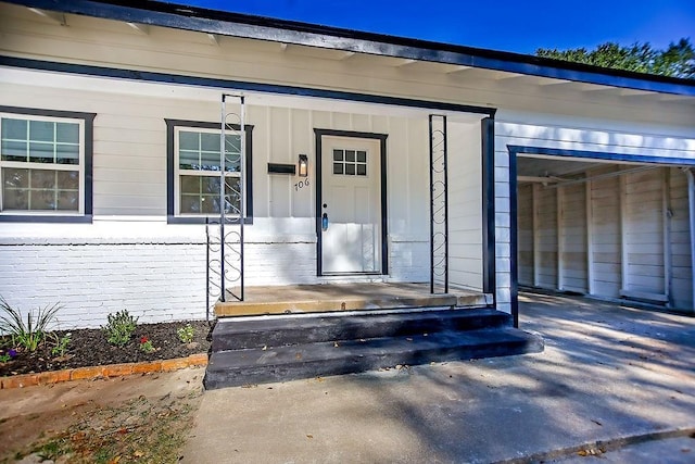 view of exterior entry featuring covered porch