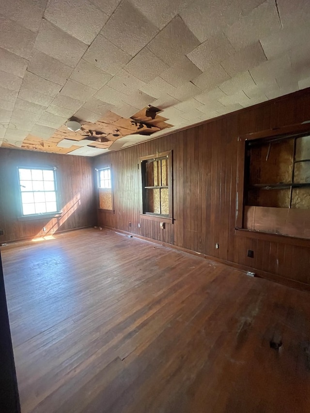 spare room featuring hardwood / wood-style flooring and wooden walls