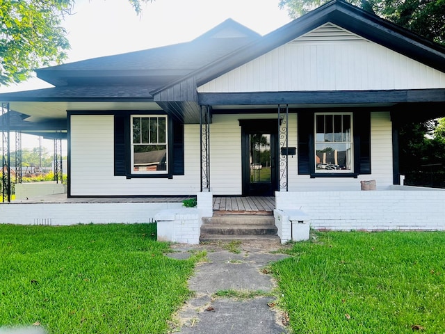 505 N 1st St, Lufkin, TX 75901 - view of front of house with covered porch, a front yard, and a shingled roof