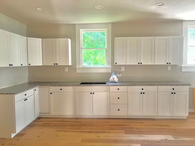 505 N 1st St, Lufkin, TX 75901 - kitchen with white cabinetry, light wood-style floors, recessed lighting, and light stone counters