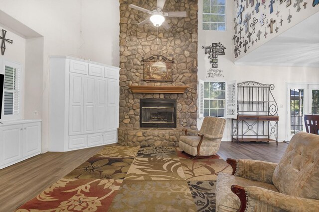 7332 Fm 252, Jasper, TX 75951 - living room featuring wood finished floors, a towering ceiling, a fireplace, a ceiling fan, and healthy amount of natural light