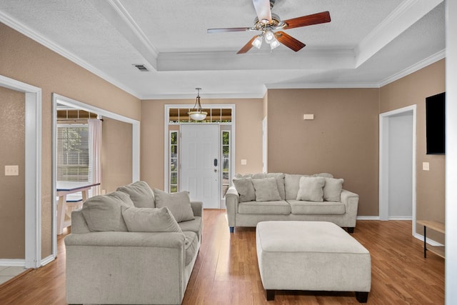 126 Lewellin Pl, Lufkin, TX 75904 - living room featuring a raised ceiling, healthy amount of natural light, a ceiling fan, wood finished floors, and crown molding