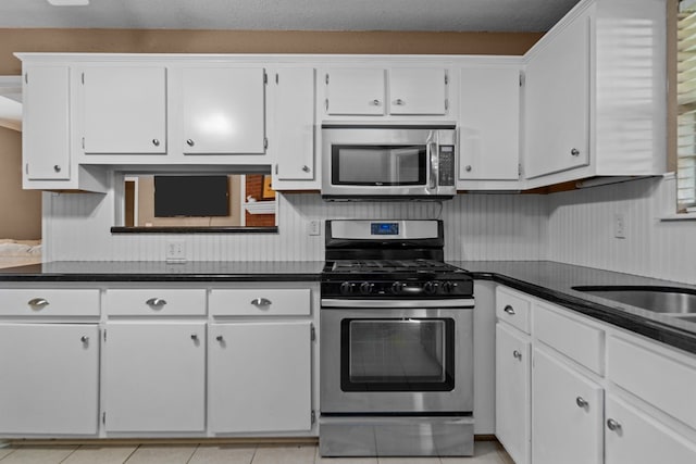 126 Lewellin Pl, Lufkin, TX 75904 - kitchen with appliances with stainless steel finishes, dark countertops, and white cabinets