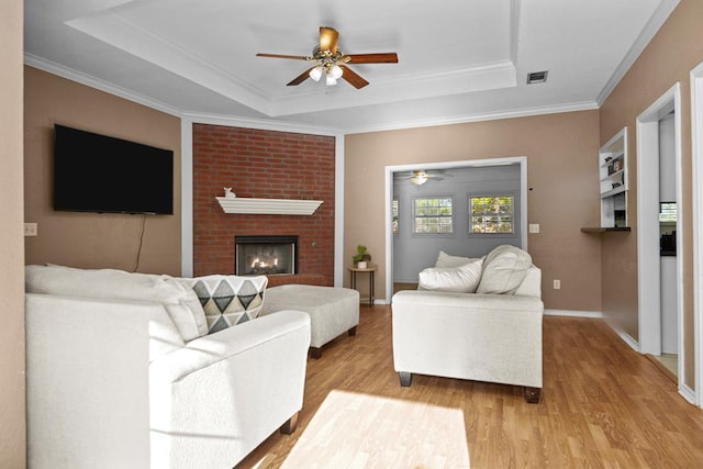 126 Lewellin Pl, Lufkin, TX 75904 - living area featuring a raised ceiling, ceiling fan, light wood-style floors, and crown molding