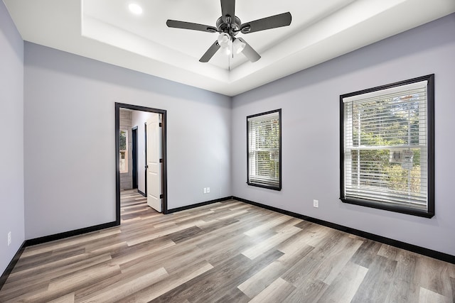 119 Park Pl, Lufkin, TX 75901 - spare room with a raised ceiling, light wood-style floors, ceiling fan, and baseboards