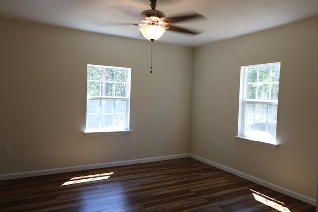 unfurnished room with plenty of natural light, dark wood-type flooring, and ceiling fan