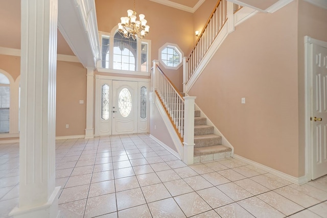 tiled entrance foyer with a notable chandelier, crown molding, and a towering ceiling