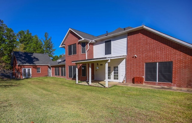 back of property featuring a patio, a yard, and french doors