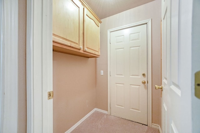 laundry room featuring light colored carpet