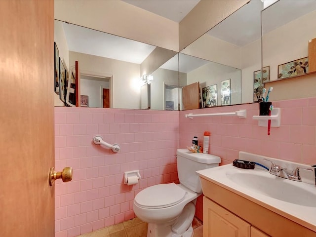 bathroom with tile patterned floors, vanity, toilet, and tile walls