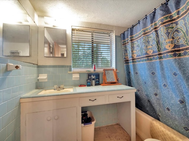 bathroom with a textured ceiling and tile walls