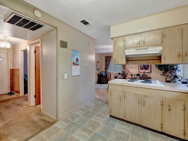 kitchen with an inviting chandelier, light colored carpet, a textured ceiling, and white stovetop