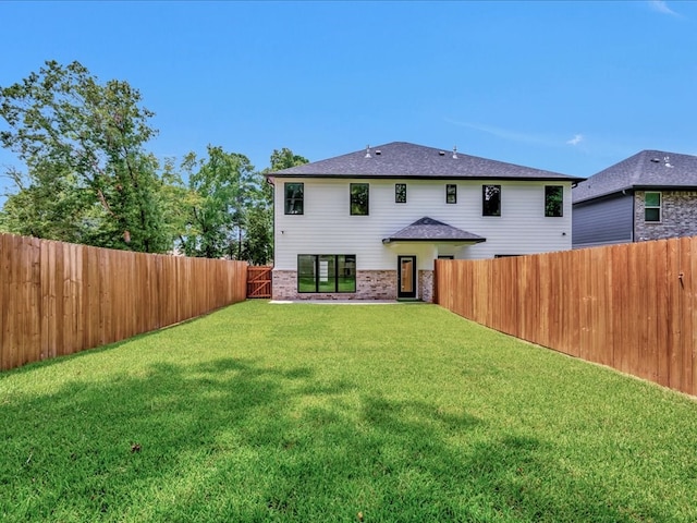 rear view of property featuring a yard