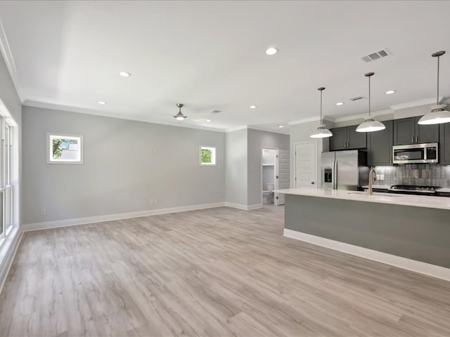 kitchen with appliances with stainless steel finishes, decorative light fixtures, and plenty of natural light