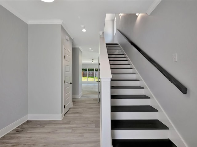 stairway with hardwood / wood-style floors and ornamental molding