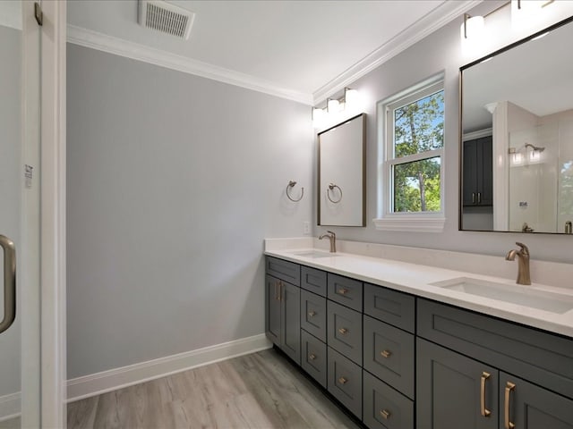 bathroom featuring crown molding, vanity, wood-type flooring, and walk in shower