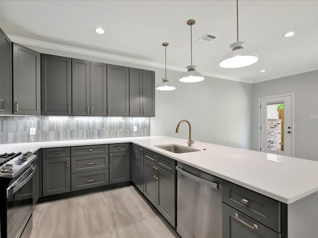 kitchen with kitchen peninsula, decorative light fixtures, stainless steel appliances, and sink