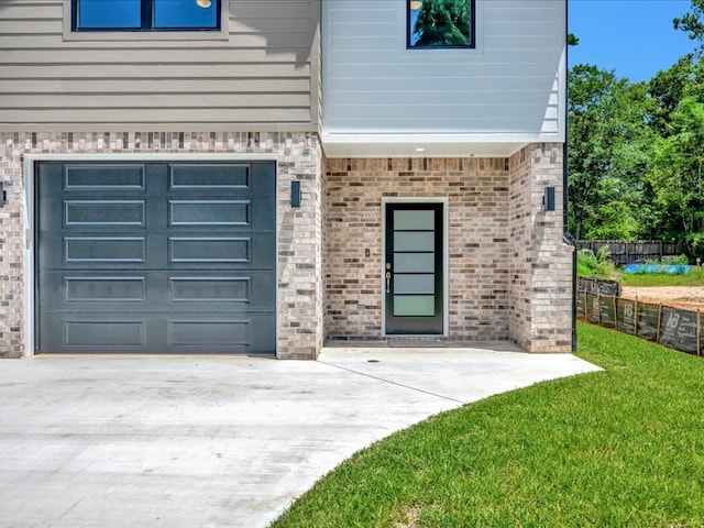 property entrance with a garage and a yard