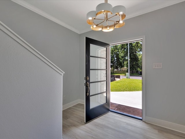 entryway with light hardwood / wood-style flooring, a chandelier, french doors, and ornamental molding