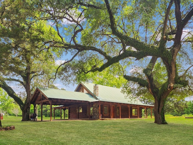 rear view of house with a yard and metal roof