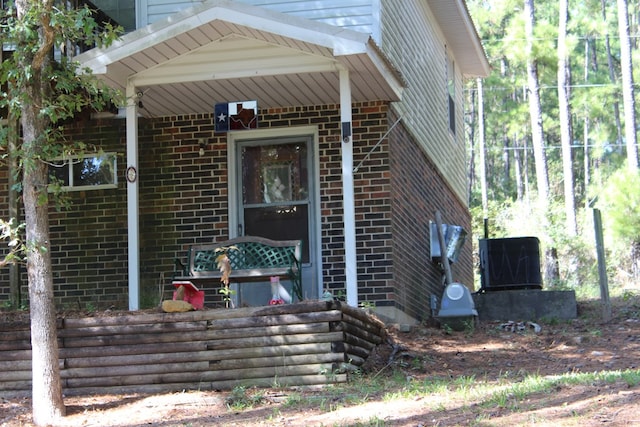 doorway to property with covered porch and central AC unit